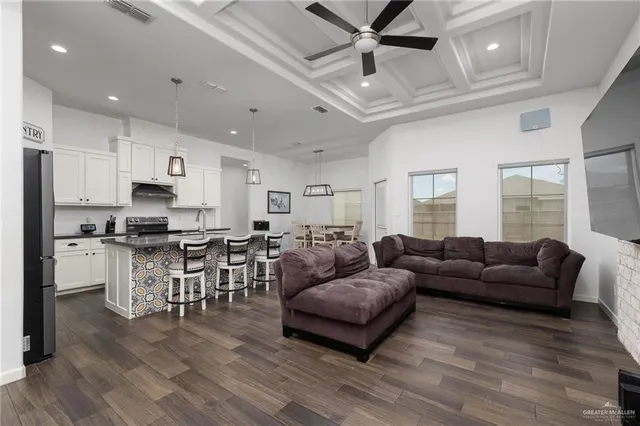 a living room with furniture kitchen view and a large window