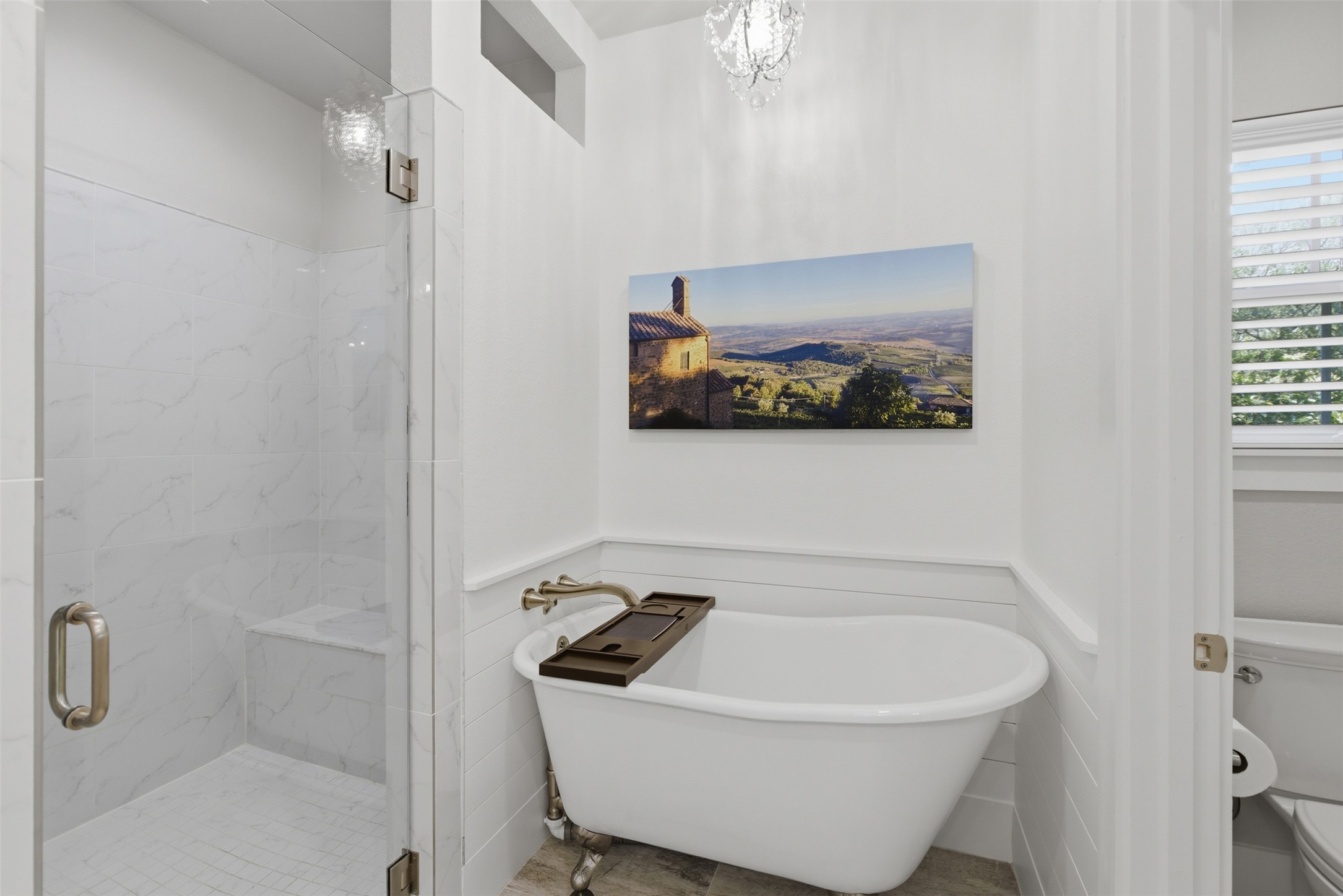 1804 Tanner Loop Taylor, TX 76574 - Photo 14 of 40 The stunning en suite features a clawfoot tub beneath a chic chandelier and a walk-in shower.