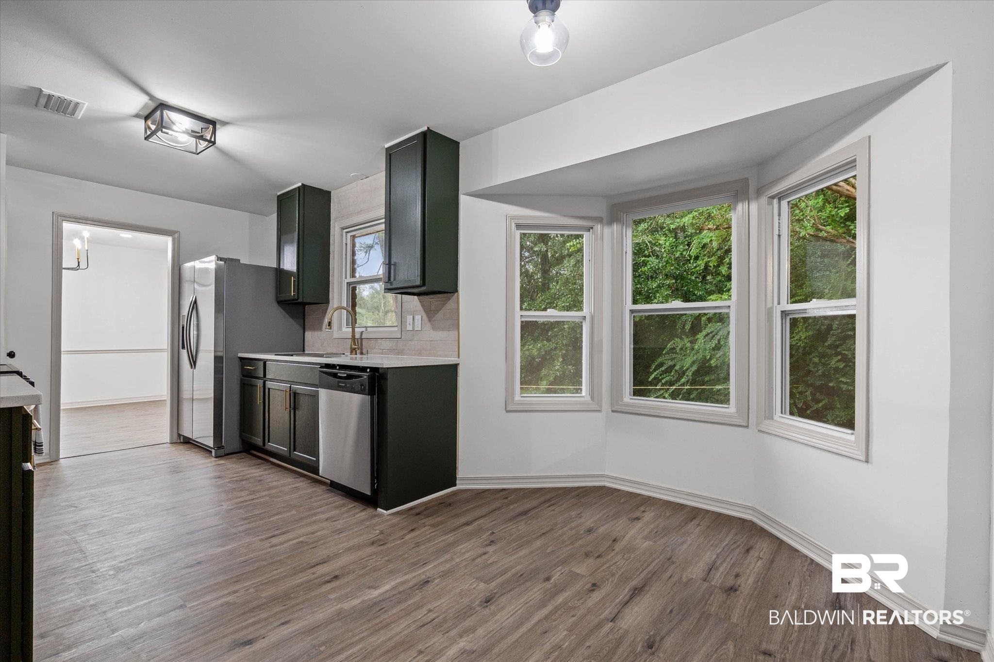 3655 Claridge Road South Mobile, AL 36608 - Photo 14 of 32 Kitchen featuring dark wood-type flooring, decorative backsplash, and appliances with stainless steel finishes