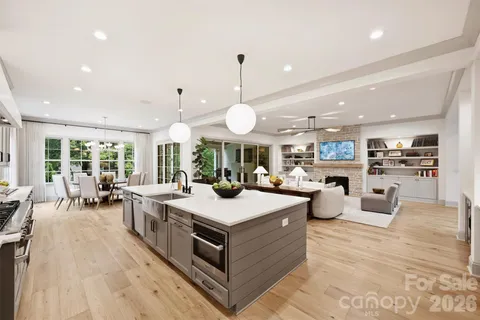 a large living room with granite countertop lots of white furniture and a large window