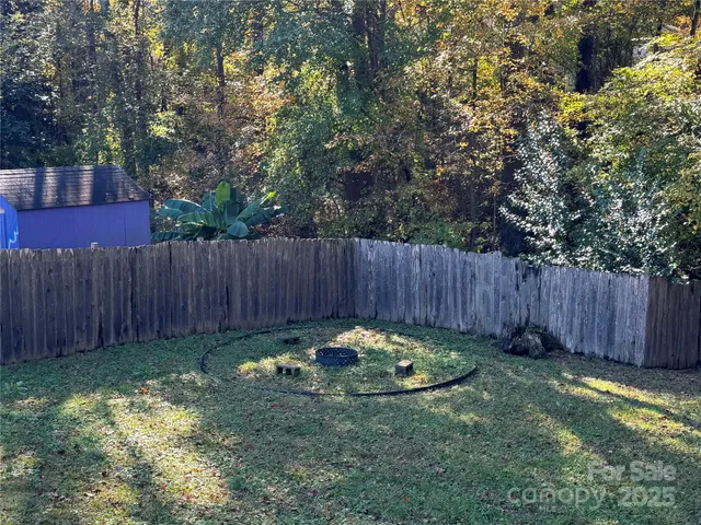 a view of garden with wooden fence