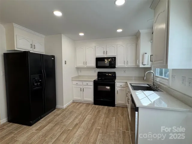 a kitchen with a refrigerator a stove top oven and a sink