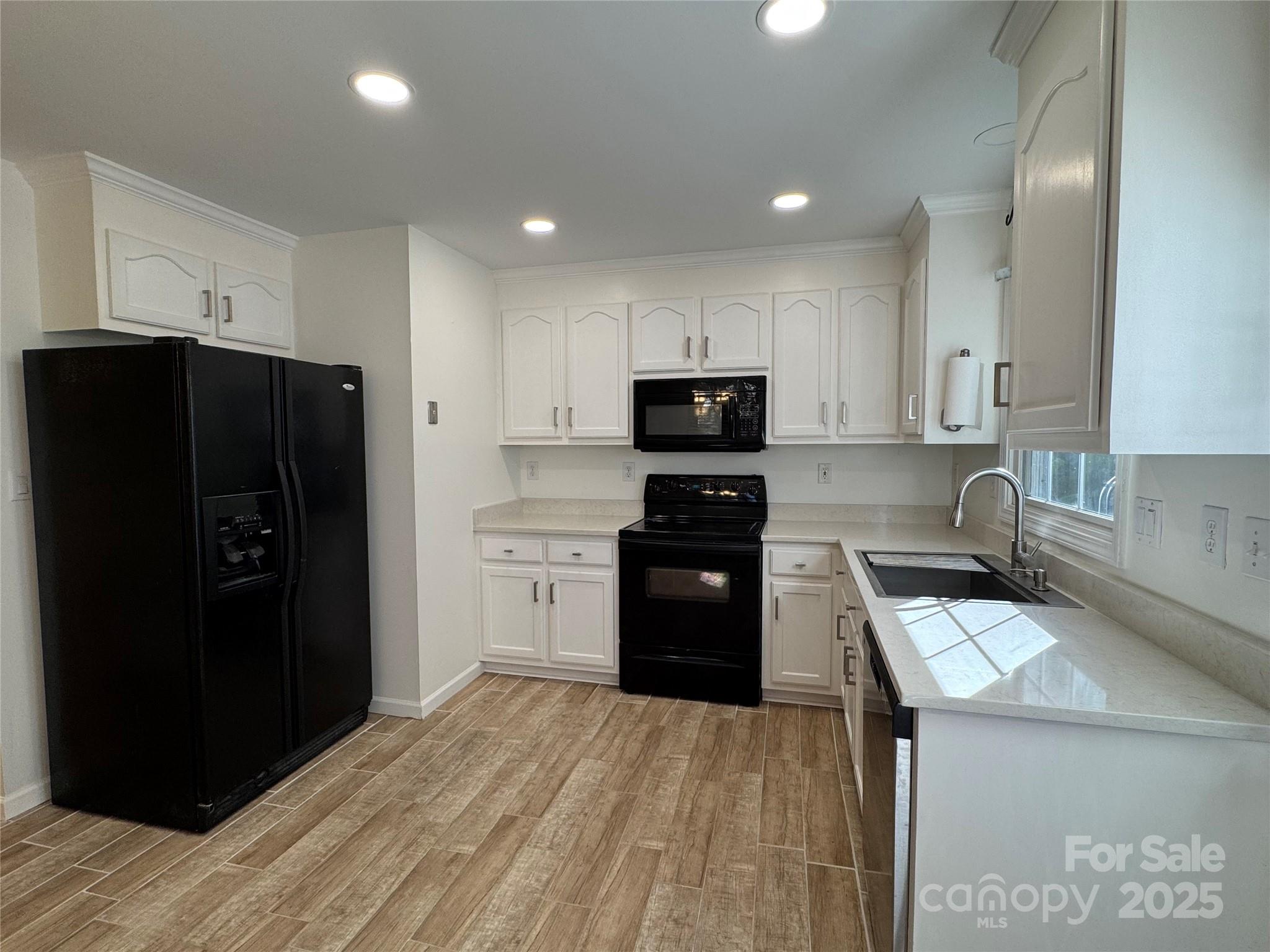 314 East Louisiana Avenue Bessemer City, NC 28016 - Photo 3 of 15 a kitchen with a refrigerator a stove top oven and a sink