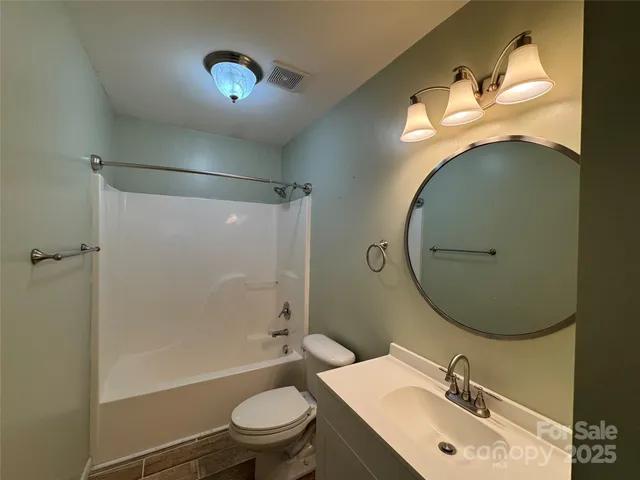 a bathroom with a sink mirror toilet and shower
