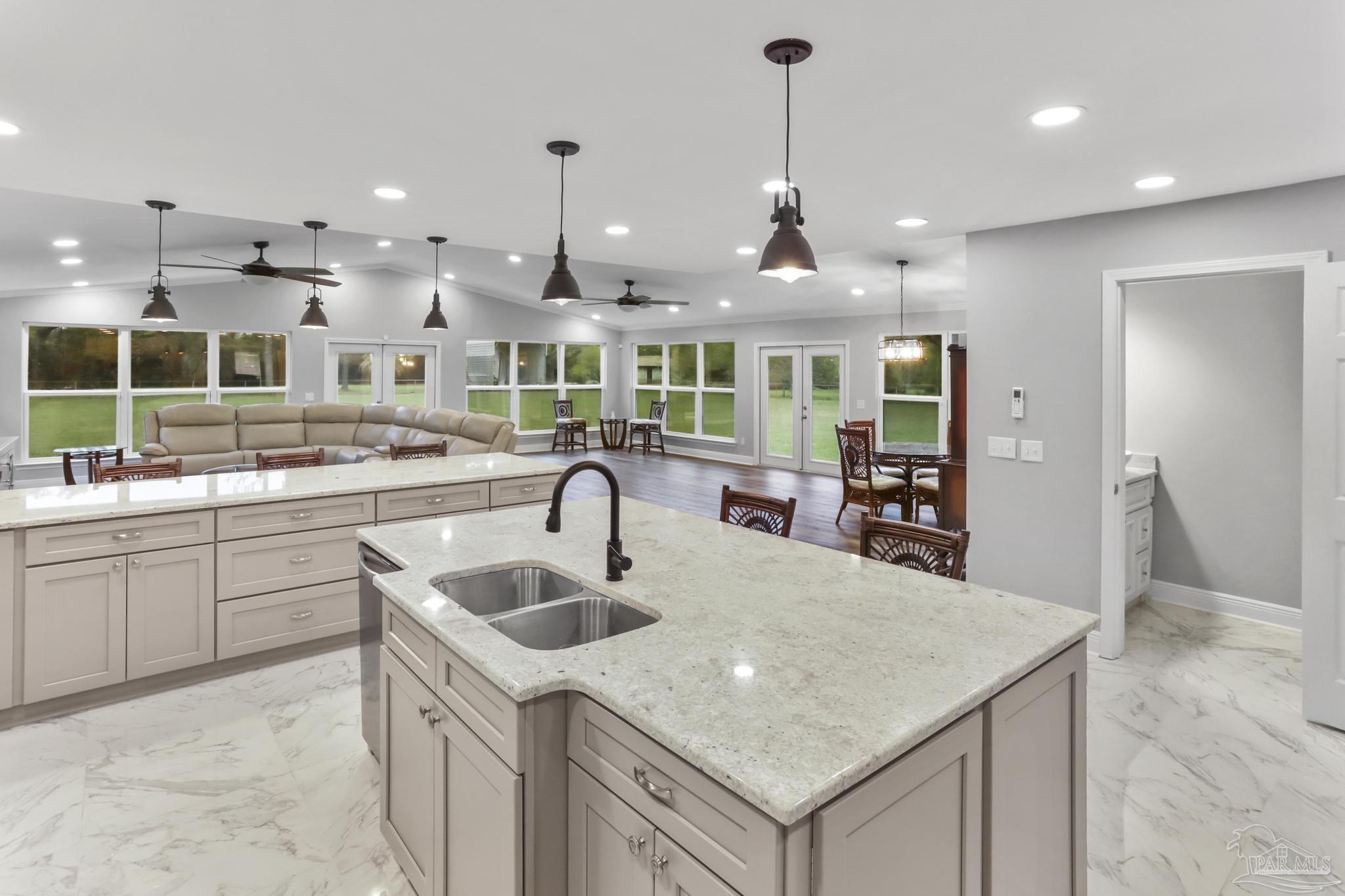 a kitchen with kitchen island a sink stainless steel appliances and a chandelier