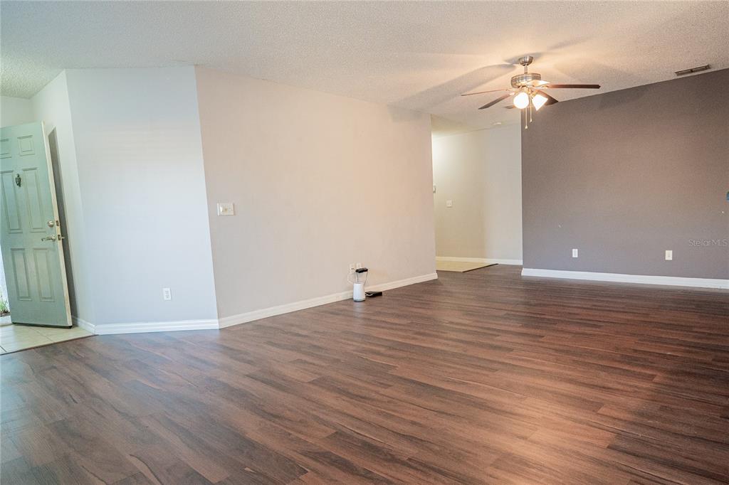 1836 Ridge Valley Street Clermont, FL 34711 - Photo 14 of 45 a view of an empty room with wooden floor and a ceiling fan