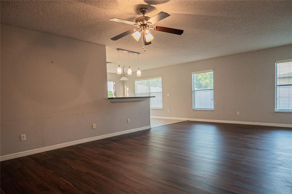 1836 Ridge Valley Street Clermont, FL 34711 - Photo 24 of 45 an empty room with wooden floor chandelier fan and windows