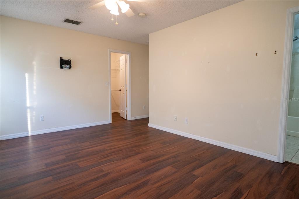 1836 Ridge Valley Street Clermont, FL 34711 - Photo 42 of 45 a view of an empty room with wooden floor and a ceiling fan