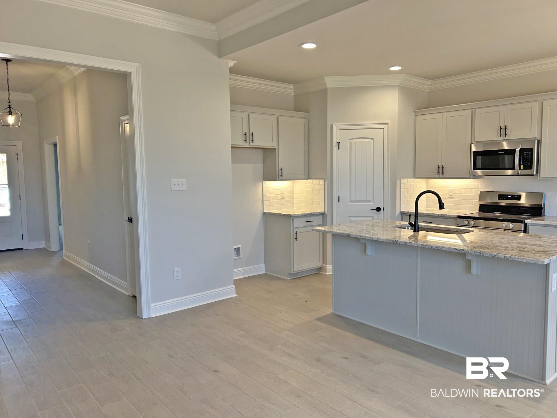 1748 Breckinridge Place Foley, AL 36535 - Photo 4 of 25 Kitchen featuring ornamental molding, light stone counters, tasteful backsplash, stainless steel appliances, and white cabinets