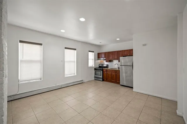 a kitchen with stainless steel appliances a refrigerator and a stove top oven