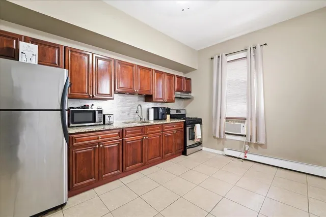 a kitchen with stainless steel appliances granite countertop a refrigerator and a sink