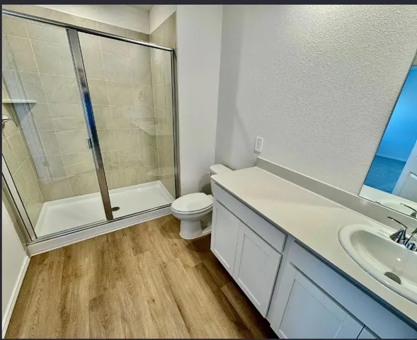 a bathroom with a granite countertop sink toilet and shower