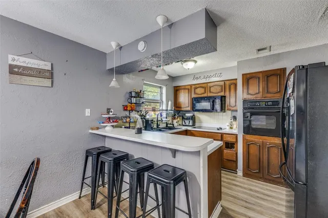 a kitchen with stainless steel appliances granite countertop a sink and a refrigerator