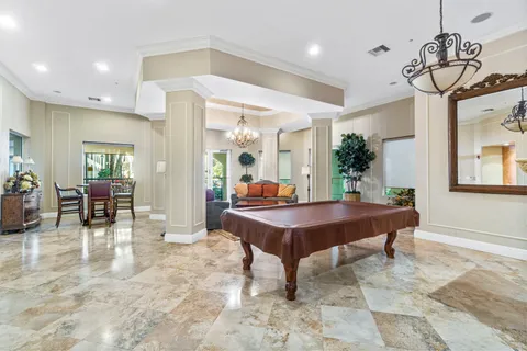 a room with furniture pool table and windows