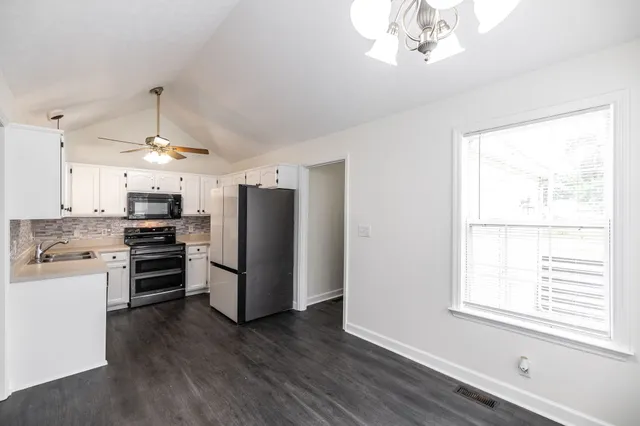 a kitchen with stainless steel appliances a stove top oven and refrigerator