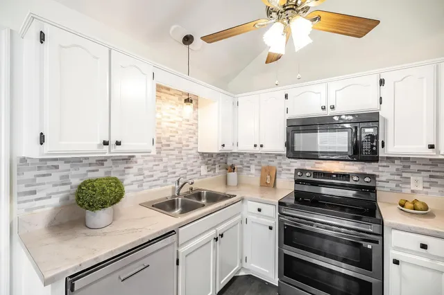 a kitchen with stainless steel appliances white cabinets and a sink