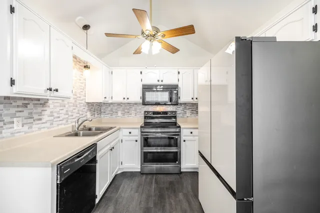 a kitchen with a sink cabinets stainless steel appliances and a window