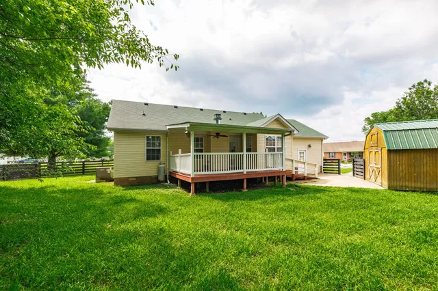 a view of a house with a big yard and large trees