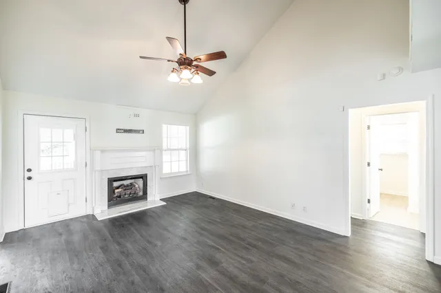 a view of an empty room with a fireplace and a window