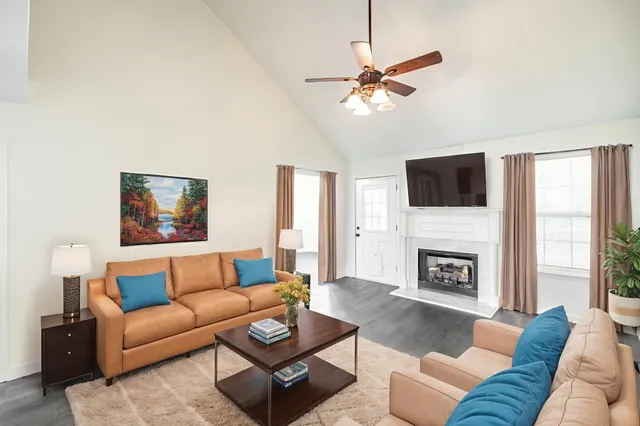 a living room with furniture a fireplace and a flat screen tv