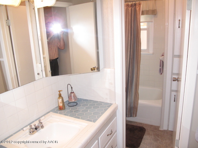 6016 Calumet Road Amarillo, TX 79106 - Photo 9 of 13 a bathroom with a sink and a mirror