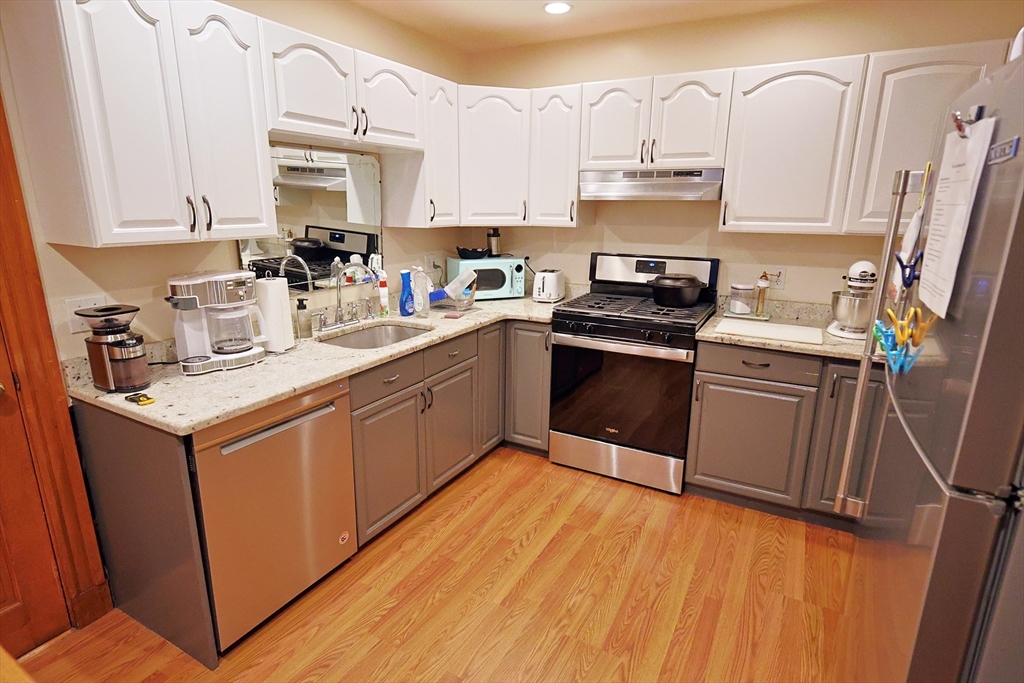 38 Ranelegh Road, Unit 1 Boston, MA 02135 - Photo 1 of 16 a kitchen with granite countertop a sink cabinets and stainless steel appliances