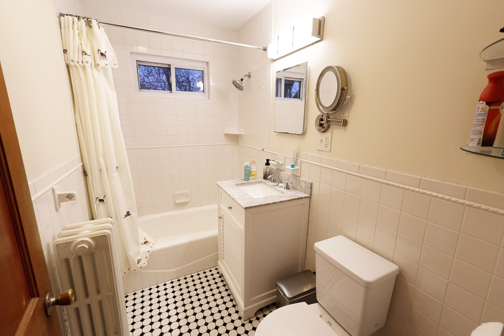 38 Ranelegh Road, Unit 1 Boston, MA 02135 - Photo 13 of 16 a bathroom with a sink a toilet and a mirror