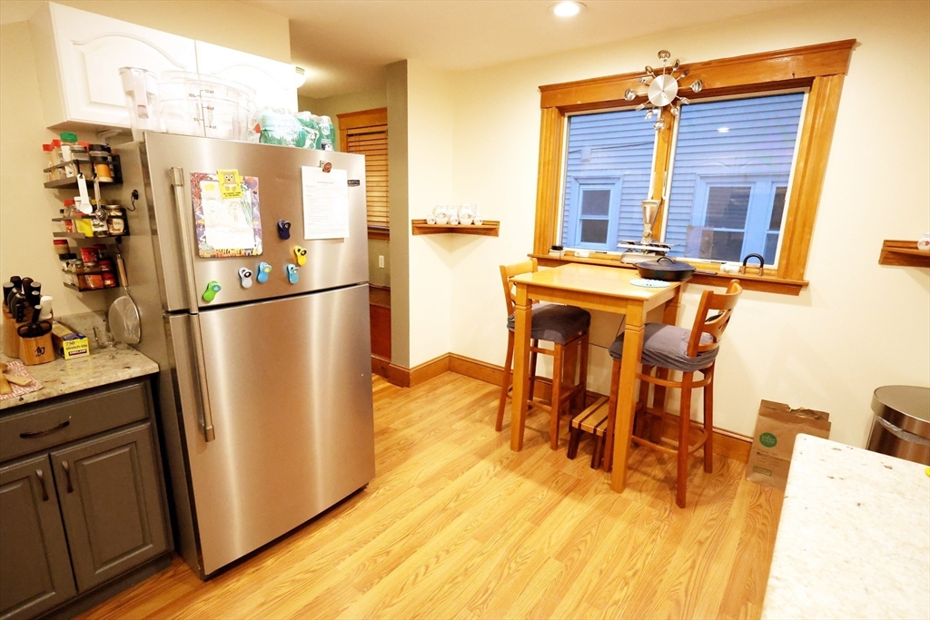 38 Ranelegh Road, Unit 1 Boston, MA 02135 - Photo 4 of 16 a kitchen with stainless steel appliances granite countertop a refrigerator a stove and a dining table with wooden floor