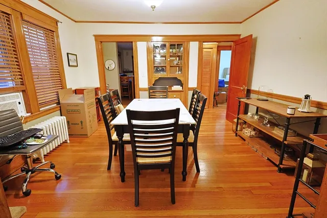 a dining room with furniture window and wooden floor