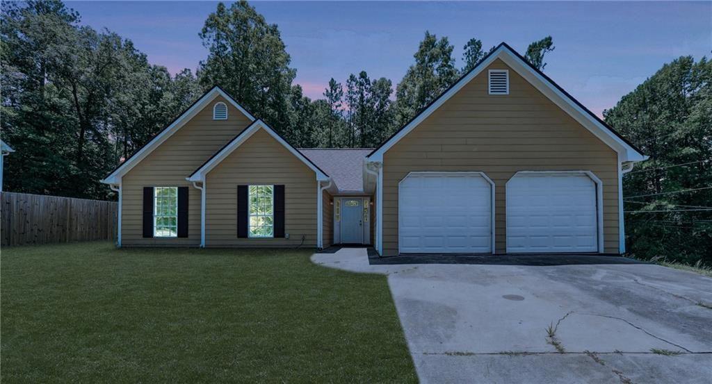 6445 Marsham Drive Atlanta, GA 30349 - Photo 1 of 28 a front view of a house with a yard and garage