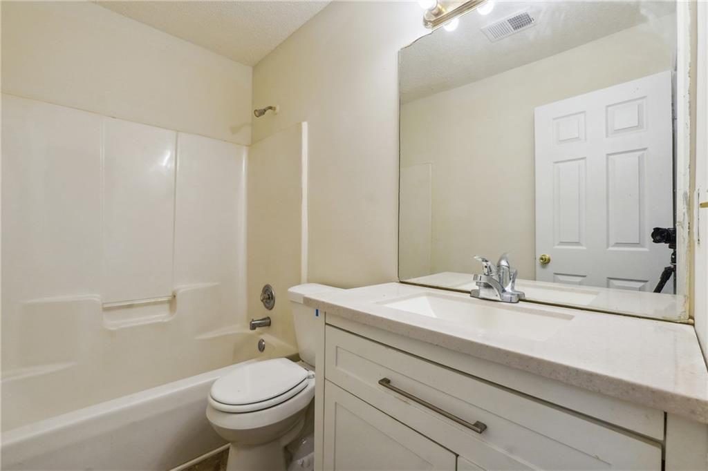 6445 Marsham Drive Atlanta, GA 30349 - Photo 21 of 28 a bathroom with a sink a toilet and shower