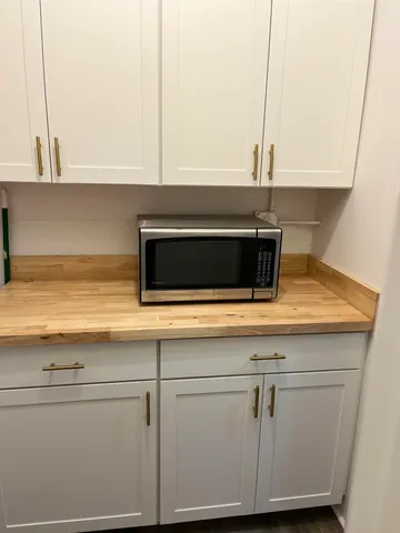 a kitchen with granite countertop white cabinets and a stove