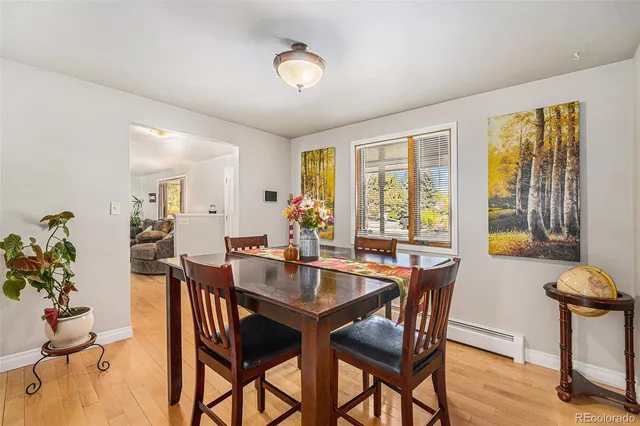 a view of a dining room and livingroom with furniture wooden floor and a window