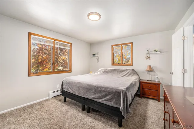 a bathroom with a granite countertop toilet a sink a mirror and a shower