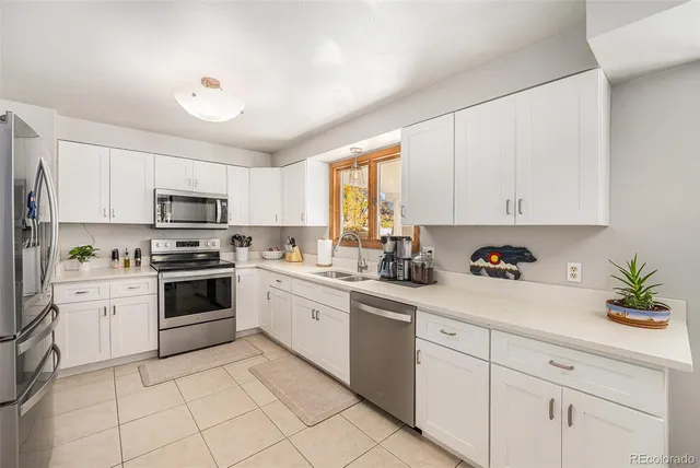 a kitchen with white cabinets appliances and a sink