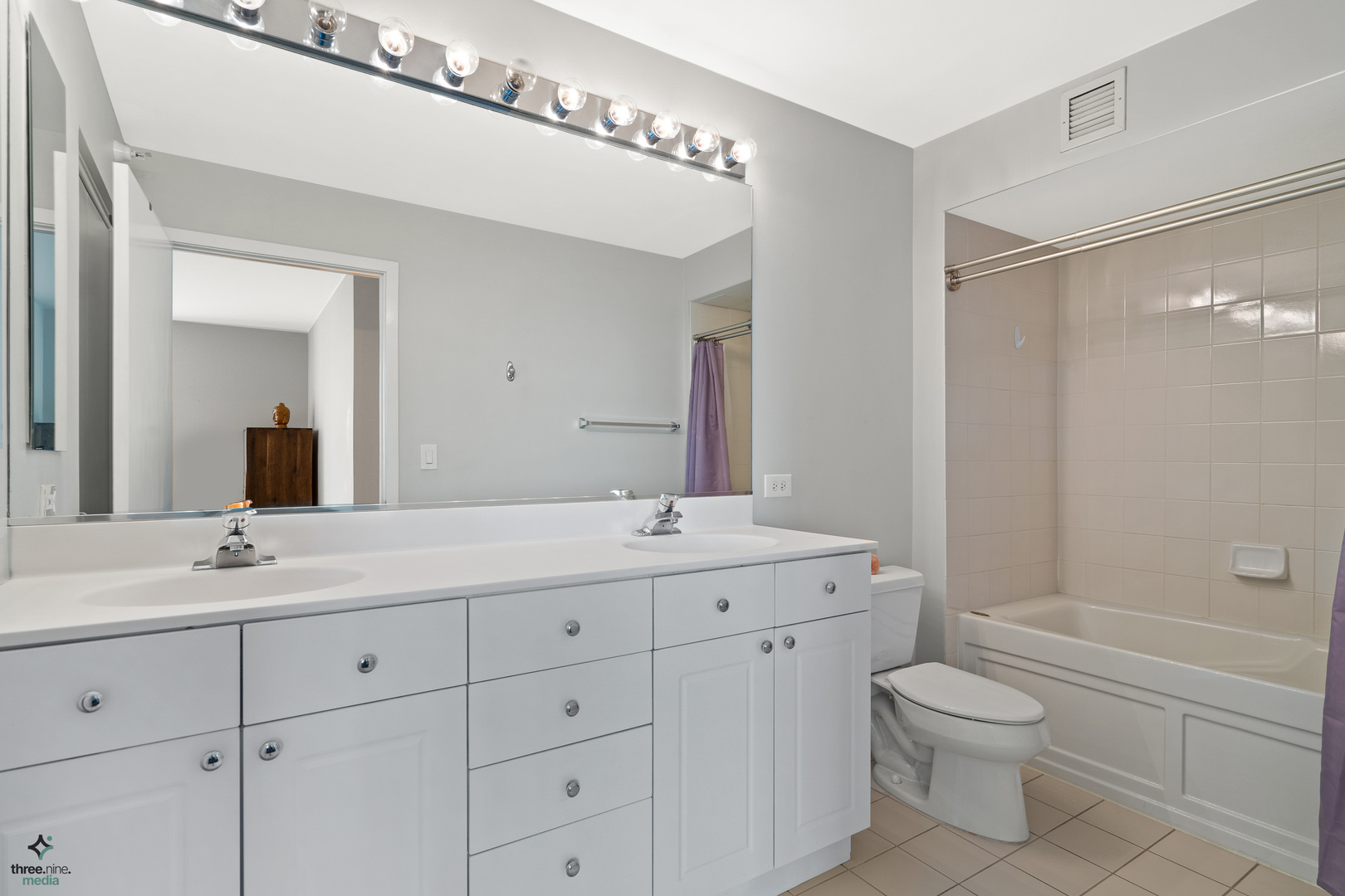 1640 Maple Avenue, Unit 1205 Evanston, IL 60201 - Photo 12 of 25 a bathroom with a granite countertop sink a toilet a large mirror and shower