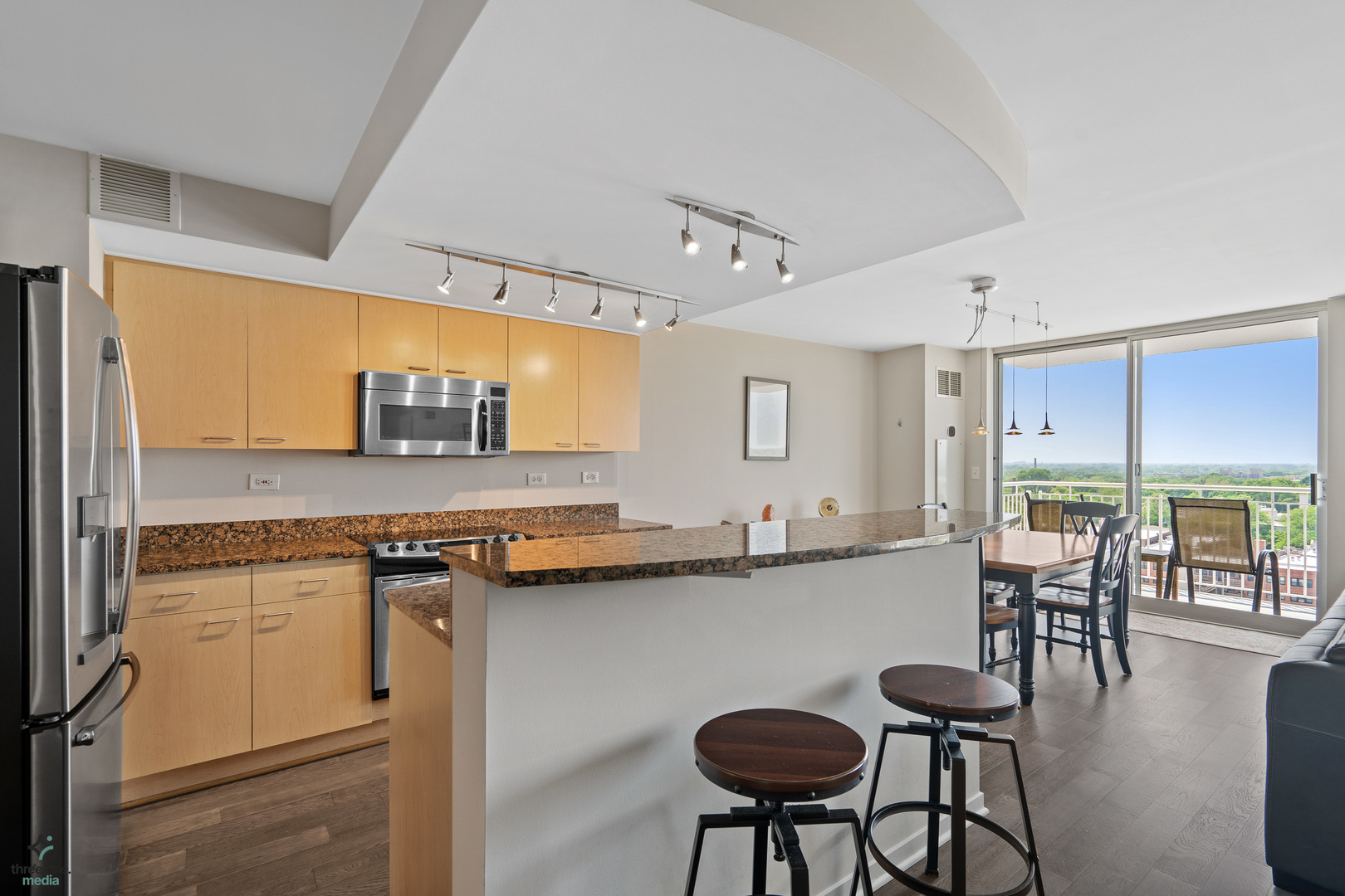 1640 Maple Avenue, Unit 1205 Evanston, IL 60201 - Photo 3 of 25 a kitchen with stainless steel appliances granite countertop a table chairs sink and cabinets