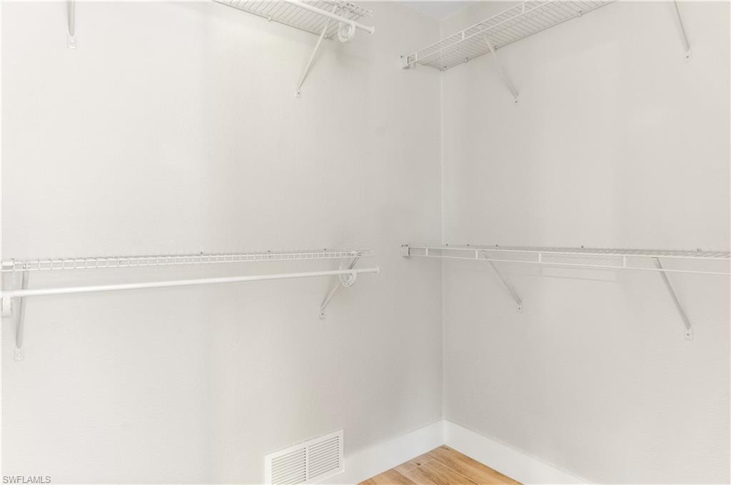 54 Liberty Lane Naples, FL 34112 - Photo 20 of 30 LARGE Walk in closet featuring light wood-style flooring