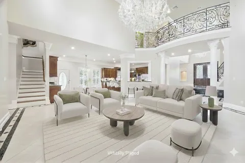 a living room with furniture a view of dining room and a chandelier