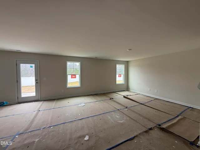 a view of an empty room with window and stairs