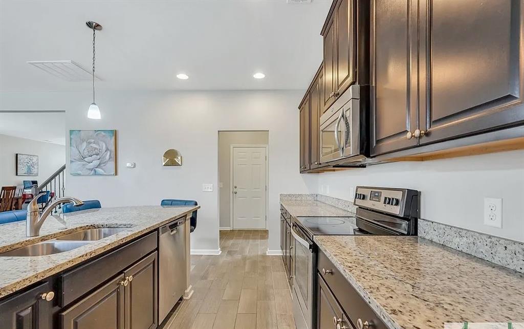 365 Southwilde Way Pooler, GA 31322 - Photo 20 of 50 a kitchen with granite countertop stainless steel appliances sink stove microwave and cabinets