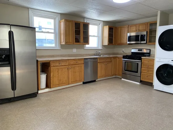 a kitchen with stainless steel appliances granite countertop a refrigerator a stove a sink and a window