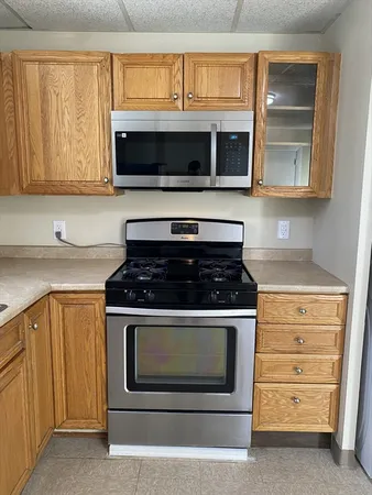 a kitchen with stainless steel appliances granite countertop a stove microwave and sink