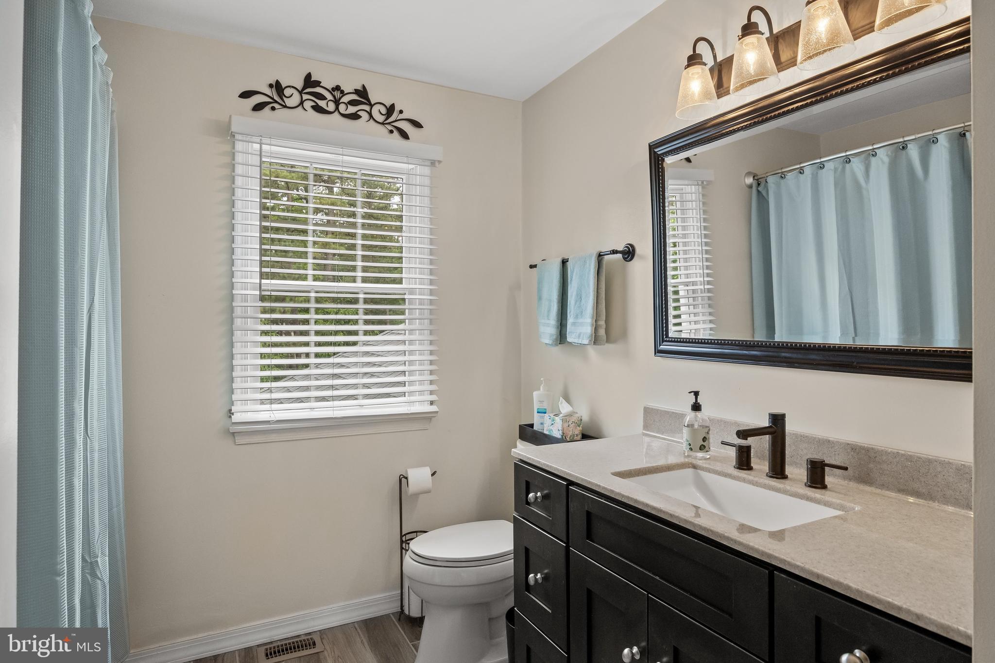 4 False Heather Way Medford, NJ 08055 - Photo 30 of 48 a bathroom with a granite countertop sink toilet a mirror and a window