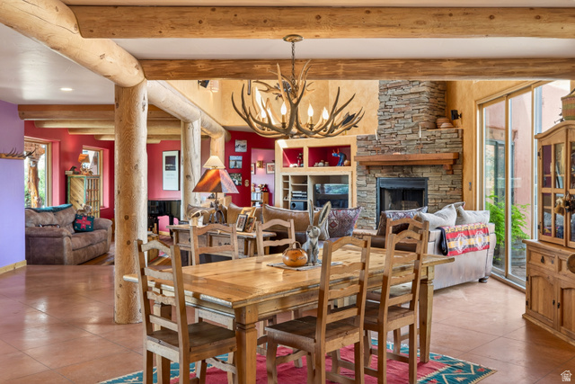 3617 Red Rock Drive Moab, UT 84532 - Photo 24 of 79 Tiled dining room featuring healthy amount of natural light, hanging lights, a fireplace, and beam ceiling