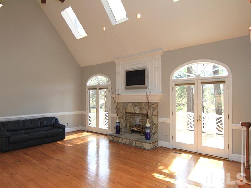 4013 Swarthmore Road Durham, NC 27707 - Photo 4 of 17 Spacious Great Room with beautiful stone and wood fireplace. Two sets of double doors leading to back deck - views of the lake. Staircase to the right leading to the second floor. Cathedral ceiling, sky lights and two ceiling fans.
