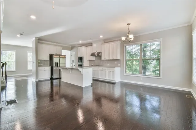 a view of kitchen with windows and refrigerator