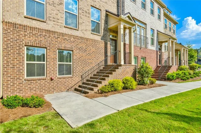 front view of a brick house with a yard