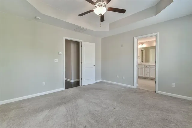 an empty room with closet and a ceiling fan