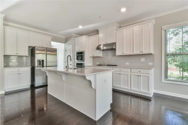 a kitchen with stainless steel appliances granite countertop a refrigerator sink and cabinets